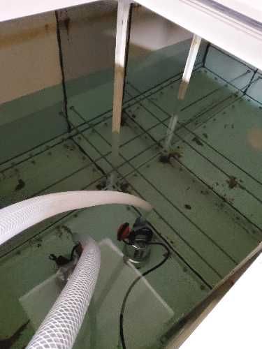 Sediment build-up inside large cold water storage tank at student accommodation building